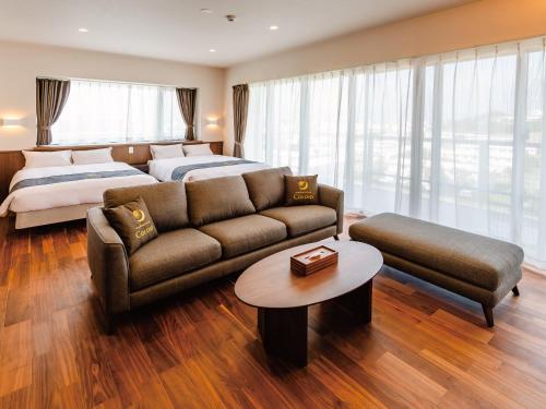 ein Wohnzimmer mit einem Sofa und einem Bett in der Unterkunft Private Condo Chatan Jagaru by Coldio Premium in Chatan
