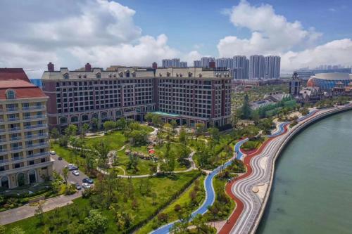 an aerial view of a large building next to the water at Doubletree By Hilton Qingdao Oriental Movie Metropolis in Huangdao