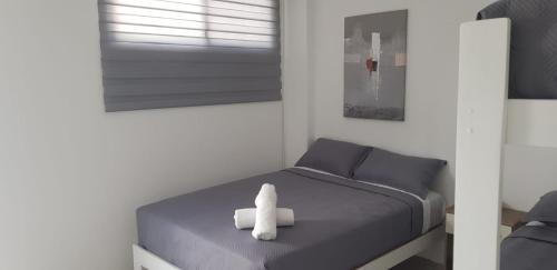 a small bedroom with a white stuffed animal on a bed at Hotel Villa Del Mar in Salinas