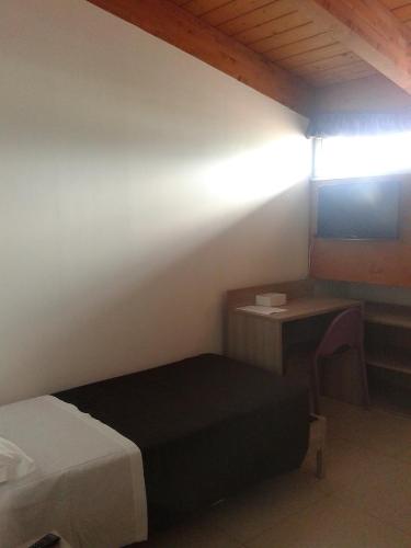 a room with a bed and a table and a desk at B&B delle Arti in Preturo