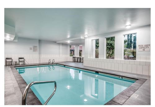 a swimming pool with blue water in a building at Holiday Inn Express Federal Way - Seattle South by IHG in Federal Way