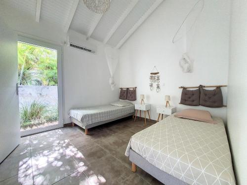 a bedroom with a bed and a window at cannelle in Sainte-Anne