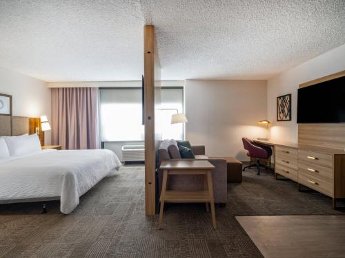 a hotel room with a bed and a desk at Staybridge Suites Chicago O'Hare - Rosemont by IHG in Rosemont