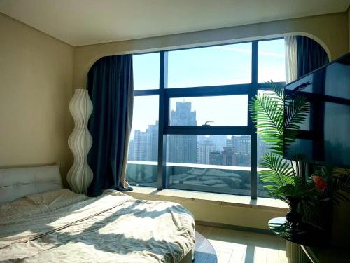 a bedroom with a large window with a view of a city at Amyitis Sky Garden - Located in the heart of Wulin with a view of Hangzhou West Lake in Hangzhou