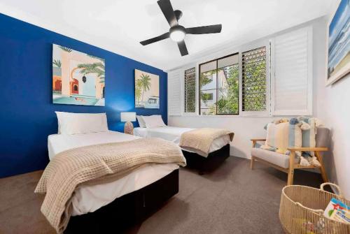 1 dormitorio con 2 camas y ventilador de techo en Copacabana Apartments, en Gold Coast