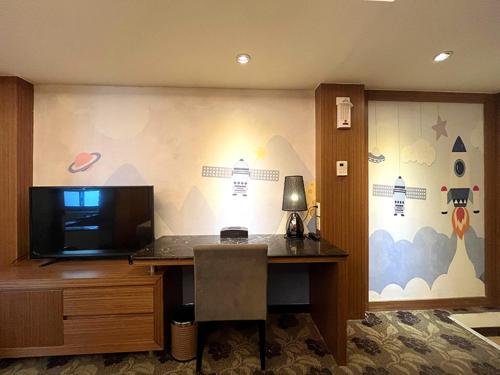 an office with a desk and a tv on a wall at JinShan Sakura Bay Hot Spring Hotel in Jinshan