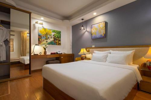 a bedroom with a large white bed and a mirror at Hortensia Flower in Hanoi