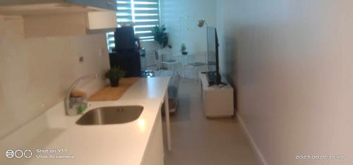 uma cozinha branca com um lavatório e uma janela em Cozy Condo with City View em San Fernando