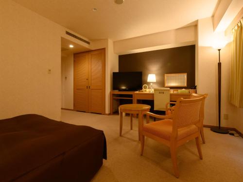 a hotel room with a bed and a desk with a computer at Sabae City Hotel in Sabae