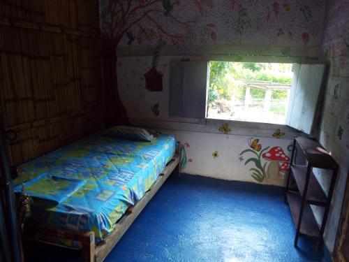 Habitación pequeña con cama y ventana en Casa surf arrels, en Montañita