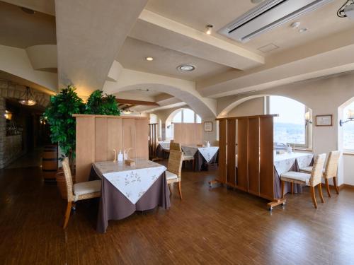 a restaurant with tables and chairs in a room at Sabae City Hotel in Sabae