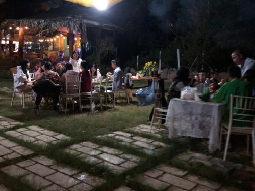 a group of people sitting at tables at night at Homestay EcoRose- Thung Lũng Hoa Hồng Điện Biên Phủ in Diện Biên Phủ