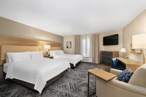 Habitación de hotel con 2 camas y sofá en Candlewood Suites Sioux Falls, an IHG Hotel, en Sioux Falls