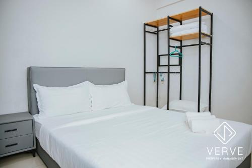 a bedroom with a white bed and a black shelf at Ipoh Majestic Premium Suites by Verve in Ipoh