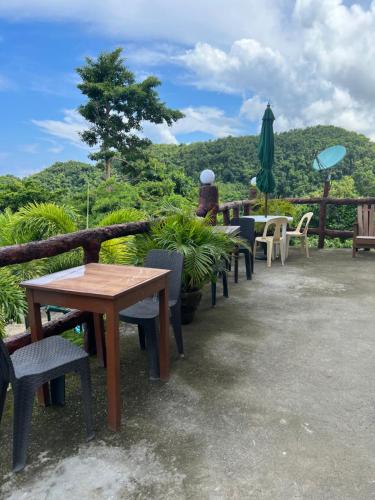 a group of tables and chairs and an umbrella at C View Resort in Sipalay