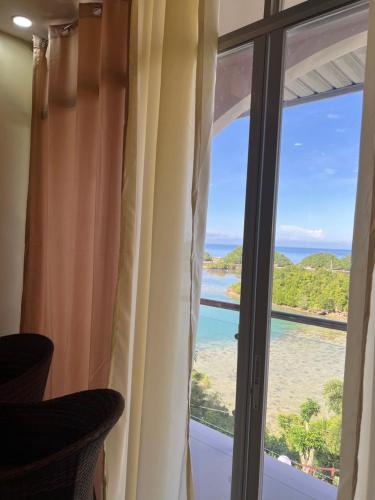 a room with a window with a view of the ocean at C View Resort in Sipalay