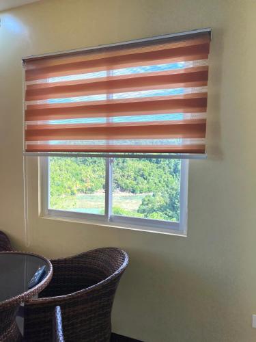 a window with a wooden blind in a room at C View Resort in Sipalay