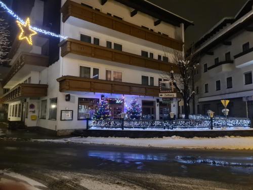 a building with christmas trees in front of it at Gasthof Hotel Kirchenwirt in Zell am Ziller