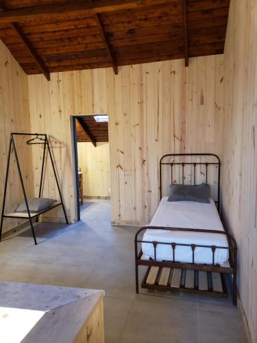 Habitación con cama en una pared de madera. en Chapa atrás - SalePatagonia en San Martín de los Andes