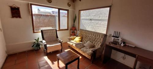 sala de estar con sofá, silla y 2 ventanas en Postal de Mar en Puerto Madryn