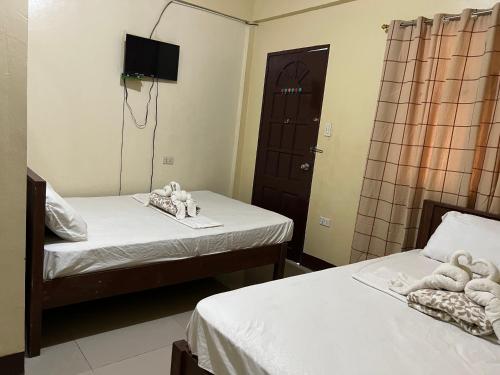 a room with two beds with stuffed animals on them at C View Resort in Sipalay