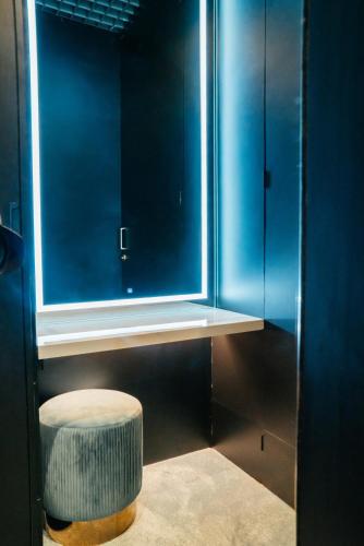 a blue bathroom with a stool and a window at CapsuleTransit Sleep Lounge KLIA T1 Airport Hotel - Landside, Public Area at Lvl 5 in Sepang
