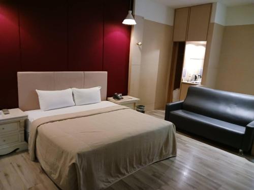 金利星精品旅館 في Nan-p'ing: غرفة نوم مع سرير وأريكة جلدية سوداء