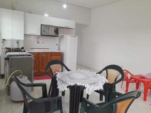 een keuken met een tafel en stoelen en een keuken met een fornuis bij Casa do Enzo in Peruíbe