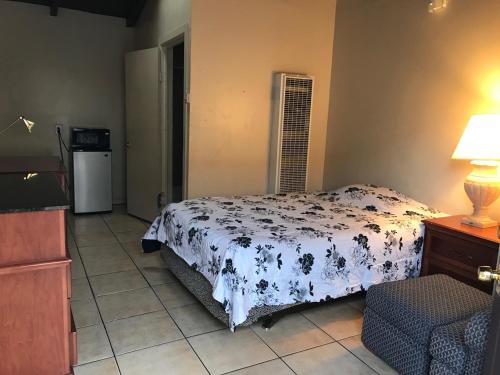 ein Schlafzimmer mit einem Bett in einem Zimmer mit einem Kühlschrank in der Unterkunft International Casa Hotel in Oakland
