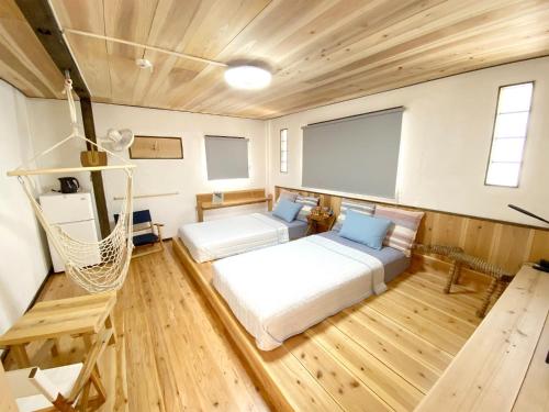 Zimmer mit 2 Betten und einer Hängematte. in der Unterkunft Yadoya LOTUS - Vacation STAY 34250v in Kabira