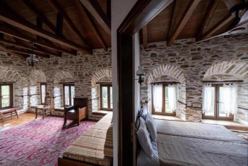 比基塔的住宿－Archontiko Michael Pelion，石头建筑中一间带床的卧室