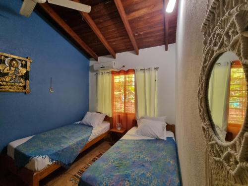 2 łóżka w pokoju z niebieskimi ścianami i oknami w obiekcie Samara Dive School w mieście Sámara