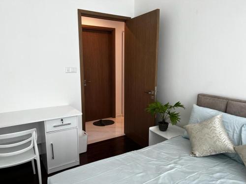 a bedroom with a bed and a desk and a bathroom at Luxury Sky Apartment in Colombo