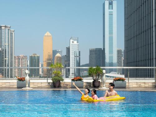 a group of people in a swimming pool in a city at Sheraton Guangzhou Hotel in Guangzhou