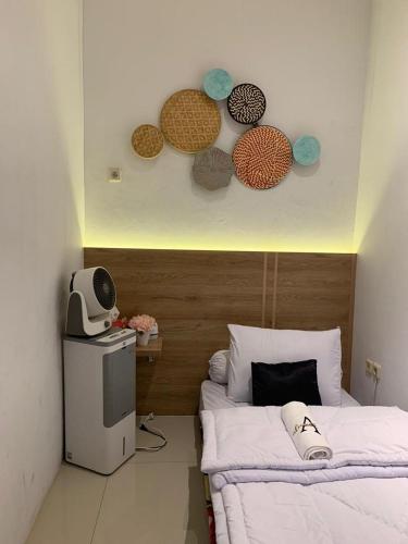 een kamer met een bed en wat borden aan de muur bij Guest House Premium Alaufbee in Jakarta