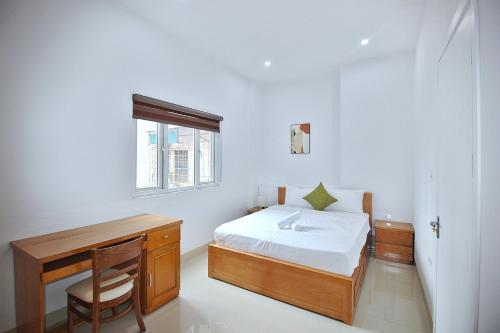 um quarto com uma cama, uma secretária e uma janela em Amor home III em Hanói