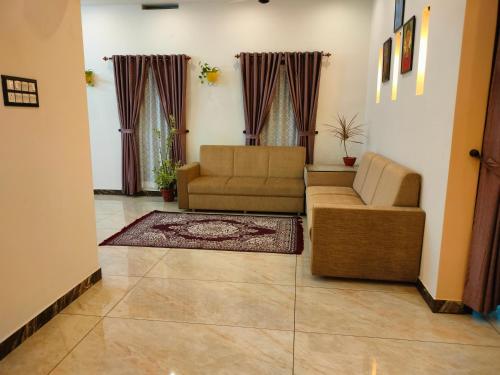 a living room with a couch and a chair at Gerards Home stay Fortkochi in Cochin