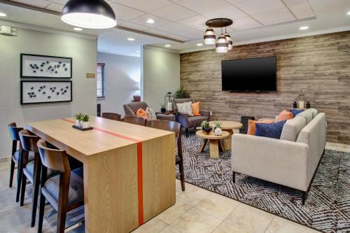 a lobby with a waiting room with a couch and a tv at Candlewood Suites Kenosha - Pleasant Prairie by IHG in Pleasant Prairie