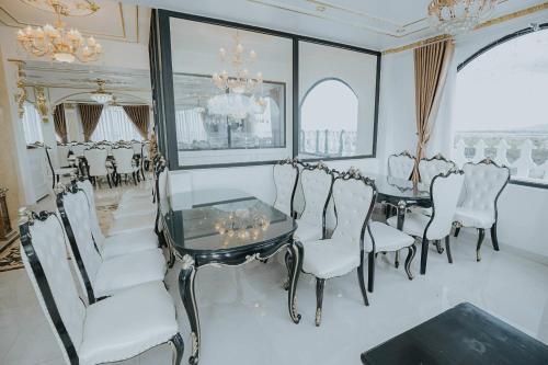 a dining room with a table and chairs and a chandelier at Hoàng Gia Hotel Tuy Hoà in Tuy Hoa