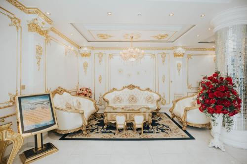 a living room with gold furniture and a vase of roses at Hoàng Gia Hotel Tuy Hoà in Tuy Hoa