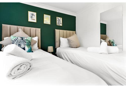 ロンドンにあるEnergizing Getaway: Newly Renovated 2 BR Flatの緑の壁のドミトリールーム ベッド2台