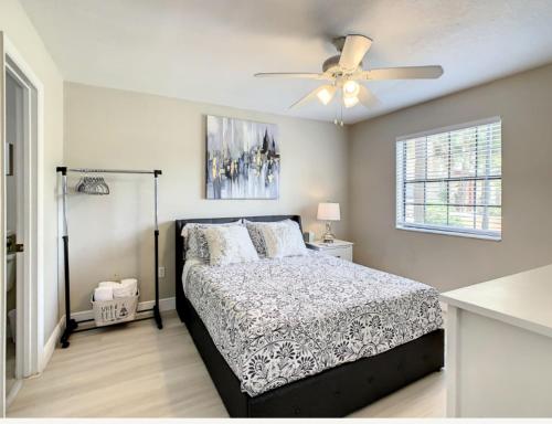 a bedroom with a bed and a ceiling fan at Charming Lakeview Retreat II only 5 Min Sea World in Orlando