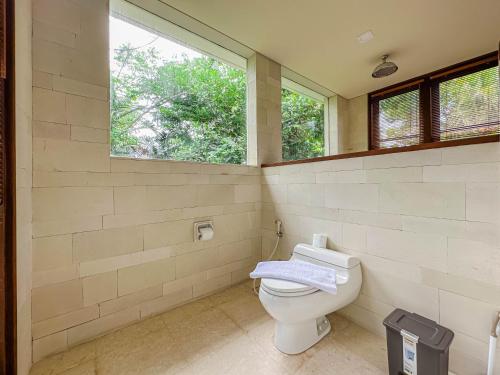 a bathroom with a toilet and a window at Villa Prinsessa in Siyut