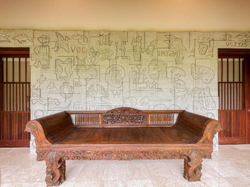 a wooden bench in front of a wall with graffiti at Villa Prinsessa in Siyut