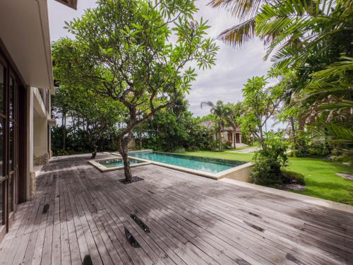 an outdoor deck with a swimming pool and a tree at Villa Prinsessa in Siyut