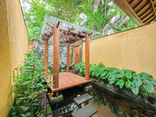 a wooden bench sitting on top of a pond at Villa Prinsessa in Siyut