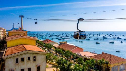a cable car flying over the water with boats at Mellon OASIS Phu Quoc in Phu Quoc