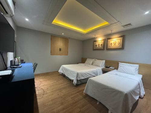 a hotel room with two beds and a tv at Urban Nest Hotel in Seoul