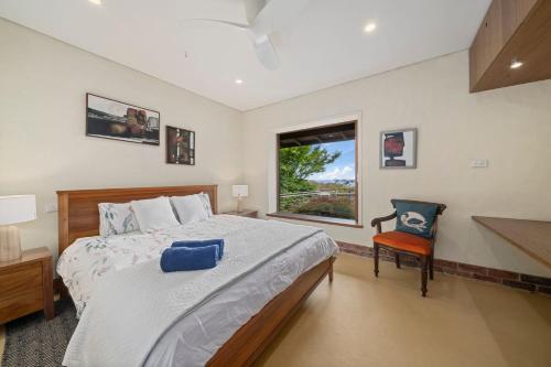 a bedroom with a bed and a chair and a window at Summer House in Wentworth Falls