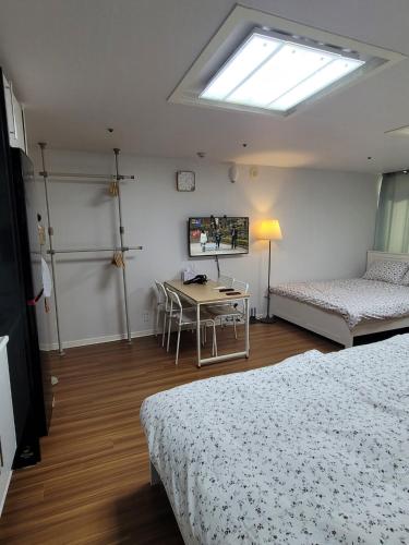 a room with two beds and a table and a window at White Stay in Seoul